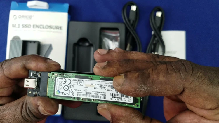 Sliding the NVMe PCIe Gen 3/4 SSD into the M.2 slot on the enclosure's internal PCB, next to the enclosure's USB-C port.